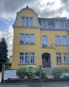 Una casa amarilla con una cúpula encima. en Ferienwohnung beethoven-12, en Zittau
