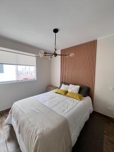 a bedroom with a large white bed with yellow pillows at HENRy in Lima