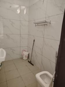 a bathroom with a toilet and a sink at Poonam's Nest in Faridabad