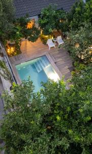 an overhead view of a swimming pool with chairs and trees at Garden Cellar - Kalamata Mediterranean Villas in Kalamata