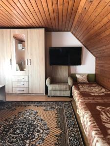 a living room with a couch and a flat screen tv at Erika-Vendégház in Poroszló