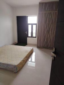 a bedroom with a bed and a wooden cabinet at Poonam's Nest in Faridabad