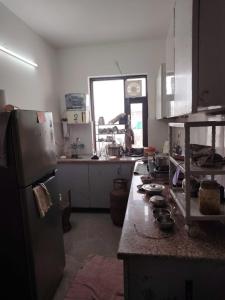 a kitchen with a refrigerator and a counter top at Poonam's Nest in Faridabad