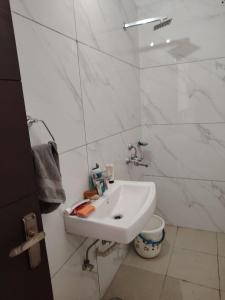 a white bathroom with a sink and a toilet at Poonam's Nest in Faridabad