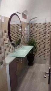 baño con lavabo verde y espejo en Casas Cuevas El Mirador con piscina y barbacoa, en Fontanar