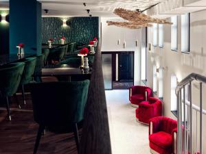 a restaurant with green chairs and a bar with red chairs at The ALD Boutique Hotel in The Hague