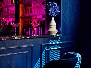 a bar with a vase of flowers and wine glasses at The ALD Boutique Hotel in The Hague