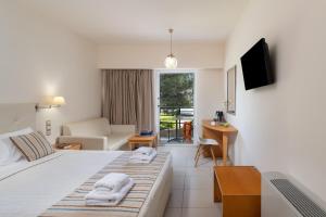 a hotel room with a bed with towels on it at Themis Beach Hotel in Kokkíni Khánion
