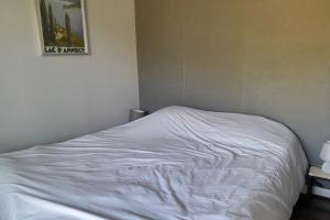 a white bed in a bedroom with a picture on the wall at Ski in and ski out apartment Superdévoluy in Le Dévoluy +5 photos