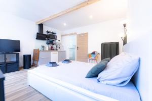 una camera da letto bianca con un grande letto bianco con cuscini blu di Superbe studio I Centre ville Saint Ausone ad Angoulême
