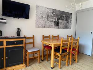a dining room with a wooden table and chairs at La Marmotine in Le Dévoluy