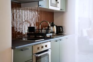a kitchen with a sink and a stove top oven at Grand Terrace 4 by Vallettastay in Valletta