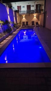 a blue swimming pool at night with lights at Flat Esmeralda Juquehy in São Sebastião