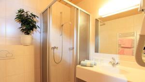 un bagno con doccia e lavandino di Hotel Dahoam by Miha a Westendorf
