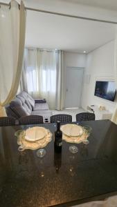 a living room with a table with wine glasses on it at Flat Esmeralda Juquehy in São Sebastião
