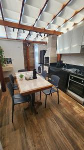 a kitchen with a wooden table and chairs in a room at Flat Esmeralda Juquehy in São Sebastião
