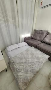 a bed and a couch in a room at Flat Esmeralda Juquehy in São Sebastião +28 photos