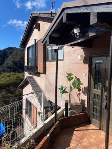 Casa rosa con balcón y puerta en Wood house pinnacle ocean view and Mountain View, en Atami