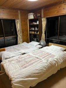 Cama grande en habitación con ventanas en Wood house pinnacle ocean view and Mountain View, en Atami 12 fotos más