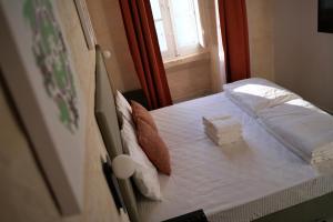a small bed in a room with a window at Grand Terrace 4 by Vallettastay in Valletta