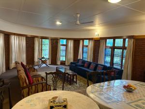 un soggiorno con divano, tavoli e finestre di Heritage Mansion a Srinagar