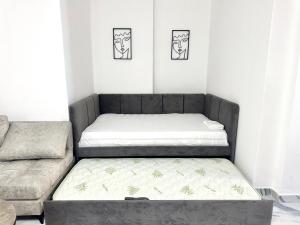 een kamer met 2 bedden en een bank bij A&H Apartment 2 in Lezhë +7 foto's