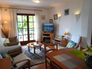 un salon avec un canapé et une télévision dans l'établissement Casa Vacacional Tranquila con Piscina, Jardín y Cerca de la Playa en L'Estartit - ES-323-29, à L'Estartit