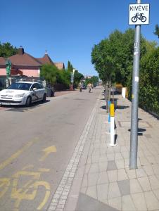 an empty street with a bike sign on a pole at Nyárfa Vendégház in Balatonmáriafürdő