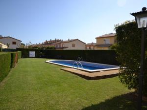 a swimming pool in a grassy yard with houses at Casa con Piscina, Cerca de la Playa y del Centro - L'Estartit - ES-323-32 in L'Estartit