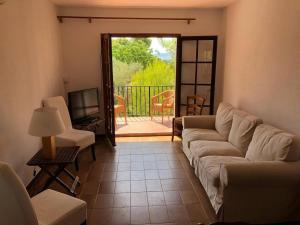 un salon avec un canapé et une télévision et un balcon dans l'établissement Casa con Jardín, Piscina, y Terrazas en Zona Tranquila Cerca de L'Estartit - ES-323-24, à L'Estartit