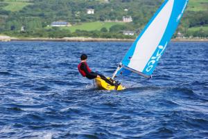 a man on a sailboat in the water at Gortnaboul House in Kilgarvan