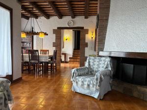 ein Wohnzimmer mit Kamin, Tisch und Stühlen in der Unterkunft Casa con Gran Jardín Privado y Piscina Comunitaria en Torroella de Montgrí - ES-323-44 in L'Estartit