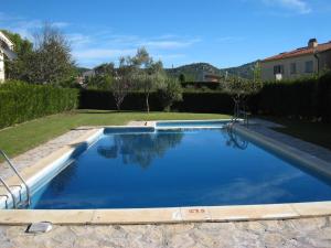 ein Swimmingpool mit blauem Wasser in einem Hof in der Unterkunft Casa con Gran Jardín Privado y Piscina Comunitaria en Torroella de Montgrí - ES-323-44 in L'Estartit