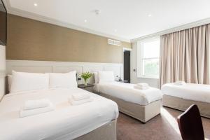 um quarto de hotel com duas camas e uma janela em Mowbray Court Hotel em Londres