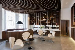 a lobby with a bar with white chairs and a counter at Mowbray Court Hotel in London +17 photos
