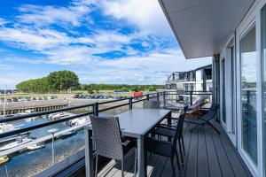 a balcony with a table and chairs and a view of a harbor at Vakantiewoning aan het water - met 2 balkons - Vista Maris - Nr 22 in Sint Annaland