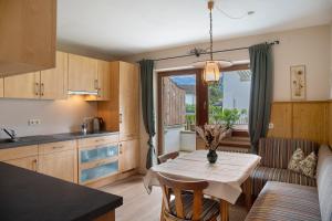 Una cocina y una sala de estar con una mesa y un sofá. en Ferienwohnung Pfingstrose, en Garmisch-Partenkirchen