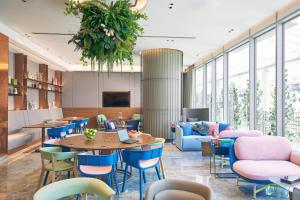 a lobby with tables and chairs and windows at Capri by Fraser China Square, Singapore in Singapore