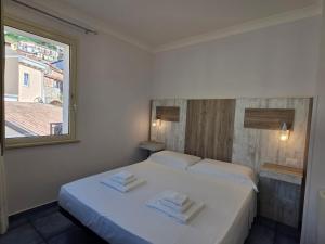 a bedroom with two white beds and a window at Residenza Calypso in Pizzo