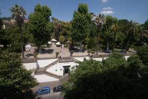 a building with cars parked in a park with palm trees at B&B Napolimilionaria Foria 242 in Naples