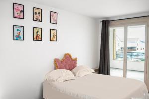 a bedroom with a white bed with pictures on the wall at Studio proche de Disneyland Paris in Bussy-Saint-Georges
