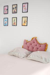 a bed with pillows and pictures on the wall at Studio proche de Disneyland Paris in Bussy-Saint-Georges