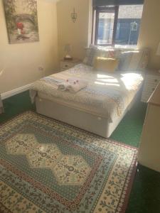 1 dormitorio con 1 cama con ventana y 2 alfombras en Edwards Cosy B&B, en Galway