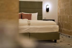 Un dormitorio con una cama con sábanas y almohadas blancas. en Grand Terrace 2 by Vallettastay, en La Valeta