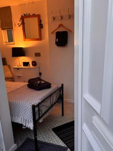 a small bedroom with a bed and a mirror at Santalijshoteliers private entrance RM 1B in Leicester