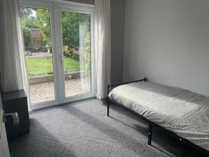 a bedroom with a bed next to a window at Cosy bungalow Branton Doncaster near Yorkshire wildlife park and doncaster centre in Cantley