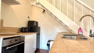 a kitchen with a sink and a counter top at Duplex - Air-conditioned - City Center in Villefranche-sur-Saône