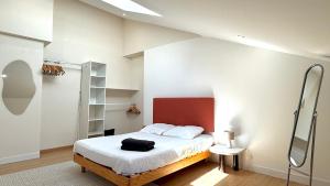 a bedroom with a bed with a red headboard at Duplex - Air-conditioned - City Center in Villefranche-sur-Saône