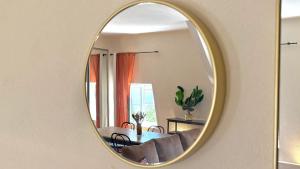 a mirror on a wall with a couch and a table at Duplex - Air-conditioned - City Center in Villefranche-sur-Saône