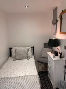 a small bedroom with a bed and a chair at Santalijshoteliers private entrance RM 1B in Leicester